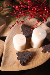 White candles with holiday greenery, creating a festive and peaceful winter ambiance