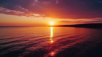 Obraz premium Breathtaking Sunset Over Calm Ocean Waters with Reflections Illuminating the Shoreline at Dusk, Capturing the Tranquil Beauty of Nature's Evening Palette