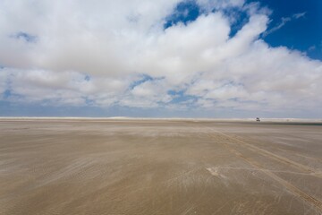 Vast sandy beach under a blue sky