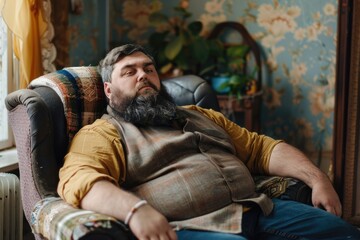 Fototapeta premium Fat People. Unhealthy Lifestyle of a Caucasian Adult Male Sitting in an Armchair