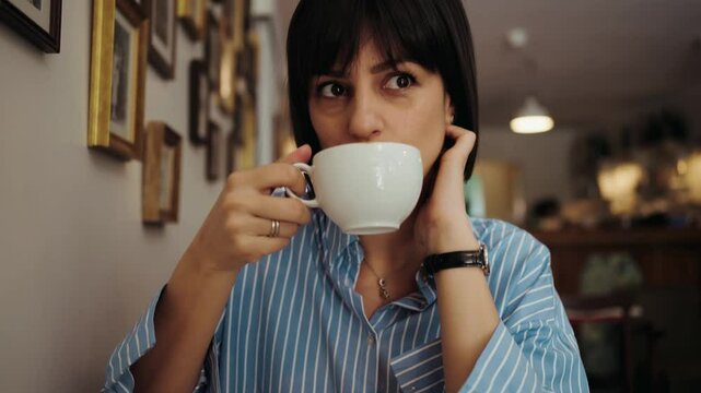Beutiful woman taking sip of coffee in cafe