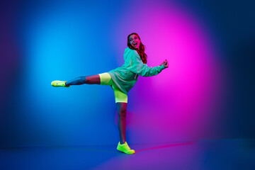 Full length photo of charming carefree woman wear green sweatshirt dancing discotheque empty space isolated neon blue color background