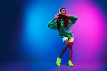 Full length photo of lovely funky girl wear green hoodie headphones having fun isolated pink light color background