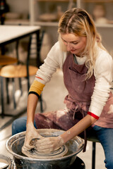 the clay modeling studio young girl hands giving shape to clay on a potter's wheel applied art clayware old craftsmanship