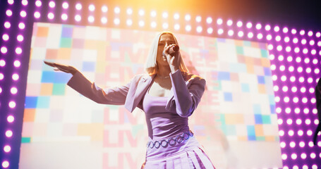 Portrait of a Beautiful Female Singer in a Striking Silver Costume. Spectacular Concert with a...