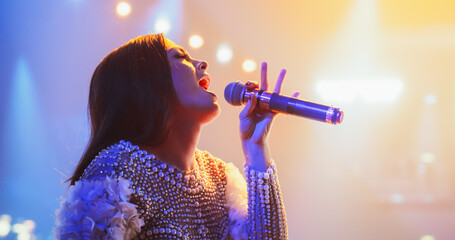 Female Pop Musician Performing Live Concert on Stage, Illuminated by a Spotlight. Epic Cinematic...