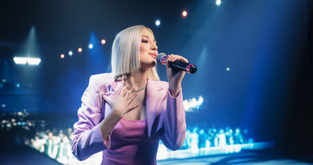 Portrait of a Beautiful Female Artist Standing on Stage at a Concert, Posing and Looking at Camera....