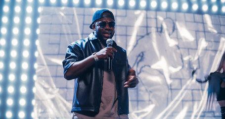 Rap Artist Performing on a Vibrant Stage with an Energetic Female Dancer, Entertaining a Large...