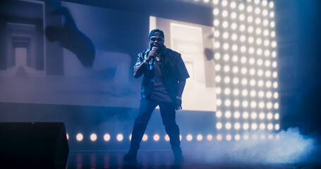 Hip Hop Concert with a Lively Performance: Young Talented Musician Performing a Show on Stage in...