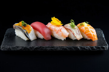 A gourmet sushi platter with assorted nigiri and sashimi, beautifully presented on a dark stone plate.