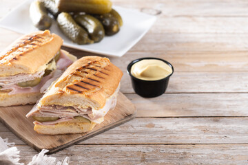 Traditional Cuban sandwich on wooden table. Copy space