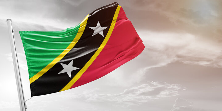 Saint Kitts and Nevis national flag cloth fabric waving on beautiful grey Background.