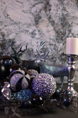 etallic and blue-toned deer figurines surrounded by black and silver Christmas ornaments, set in a winter forest theme.