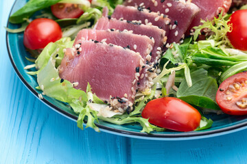Salad with raw tuna , sesame and cherry tomatoes photography . Top view