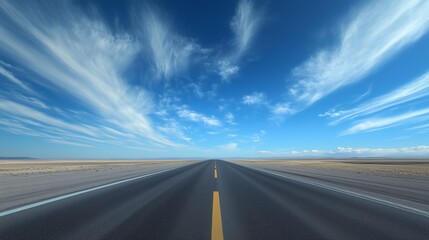 Fototapeta premium A long, straight road stretches into the distance under a vast blue sky filled with wispy clouds in a remote landscape.