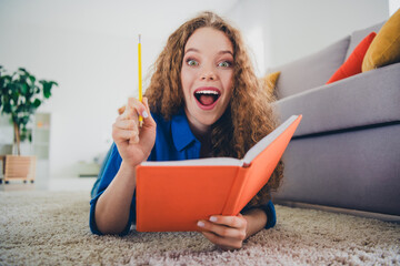 Photo of lovely cheerful girl dressed blue clothes lying floor writing diary cozy weekend day...