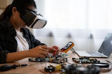 A woman is working on a computer with a VR headset on. She is fixing a computer part
