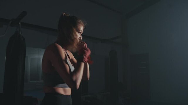 Intense evening boxing workout in a dimly lit gym with focus on technique and strength training