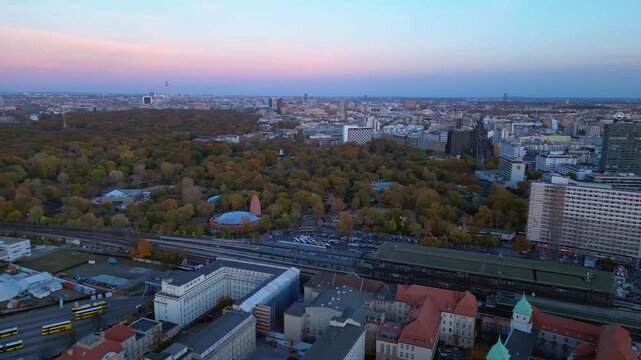 zoologischer garten train station and surrounding urban landscape in berlin, germany during sunset. Smooth aerial view flight panorama overview drone