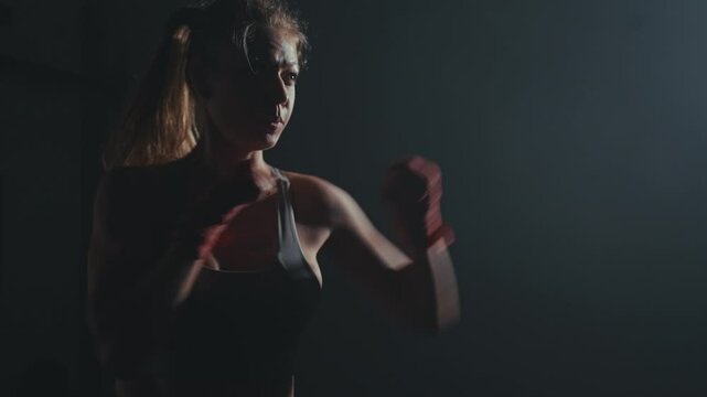 Focused fighter trains in dimly lit gym at dusk for upcoming boxing match