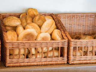 Fresh Kaiser rolls stacked in a basket on a store shelf. Bakery display case with golden brown rolls. Perfect for sandwiches or breakfast. Crispy, freshly baked roll. Healthy eating