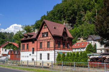 historical architectural building among rocky mountains with green trees under blue sky