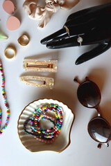 Hand figurine, sunglasses, gold jewelry, colorful bead jewelry, statement rings and various hair...