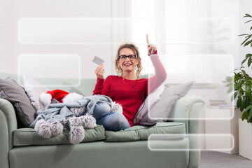 Obraz premium A woman sits comfortably on her couch at home, using her smart glasses to browse the internet for Christmas shopping, while using her credit card to make purchases and payments through her smartphone