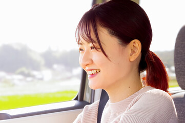 笑顔で運転をする若い女性