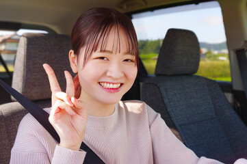 笑顔で運転をする若い女性