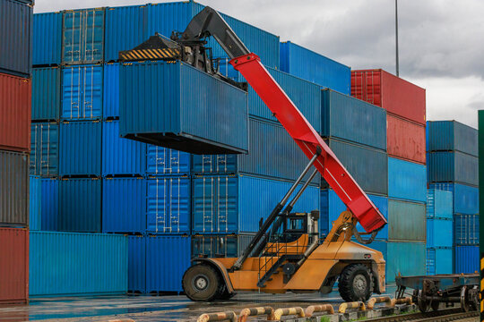 Reach stacker moves shipping container.