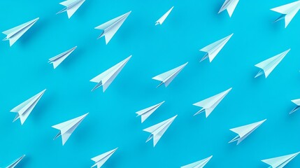 A collection of white paper airplanes scattered on a vibrant blue background.