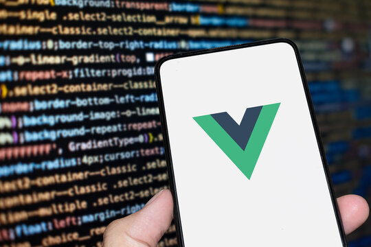 Vue JS logo sign on the smartphone screen with code background. London, UK, 11.14.2024