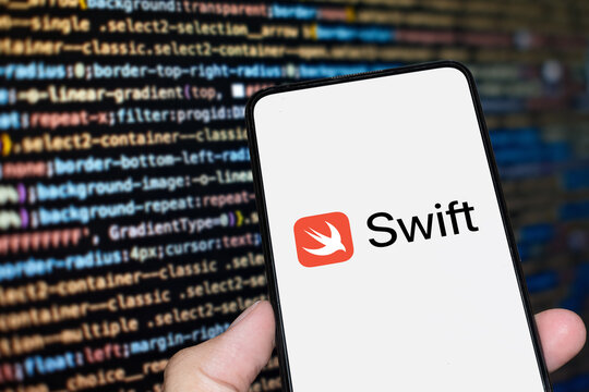 Swift IOS logo sign on the smartphone screen with code background. London, UK, 11.14.2024