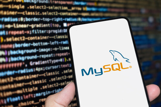 MySQL logo sign on the smartphone screen with code background. London, UK, 11.14.2024