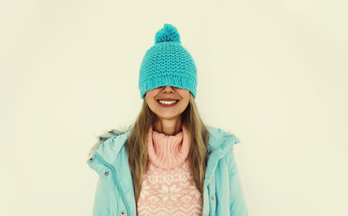 Portrait of happy funny smiling young woman in blue winter hat having fun on white background