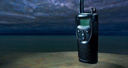 Walkie talkie with LCD display with storm over the ocean gathering behind