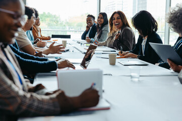 Business professionals laughing during a discussion at a meeting seminar