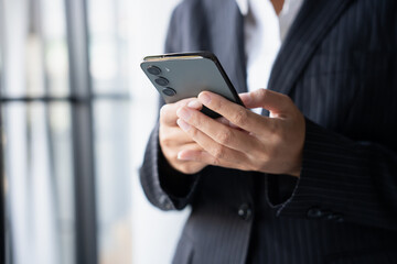 Asian Business woman using smart phone spending time checking news social media