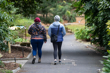 two women walking in a botanical garden park