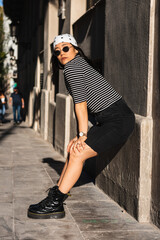 Fashionable young asian woman wearing bandana and sunglasses posing in a city street