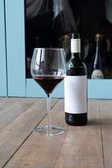 A red wine bottle and elegantly designed glass highlight sophisticated taste in a stylish, inviting setting