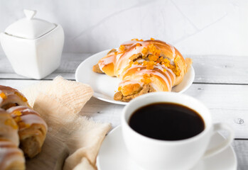 Bun, black coffee. on a light background. morning