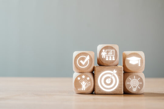 Wooden blocks with icons representing mentoring, growth, success, and education in a professional environment.