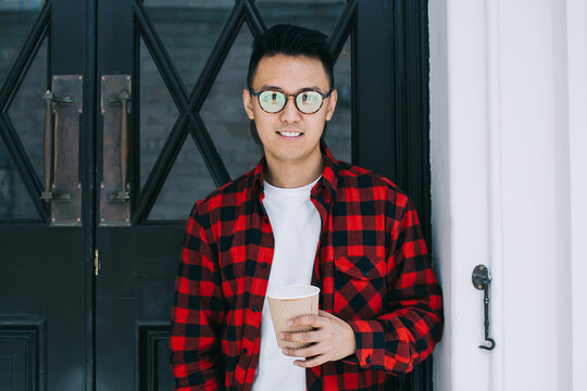 Satisfied youthful ethnic male standing at door