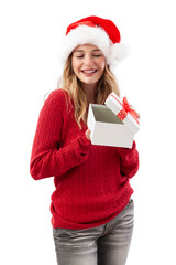 Cheerful woman opening a red Christmas present gift box while wearing a Santa hat, isolated on a...