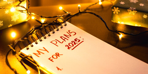 Notebook with written plans for new year 2025 in Christmas decoration. Making plans for future....