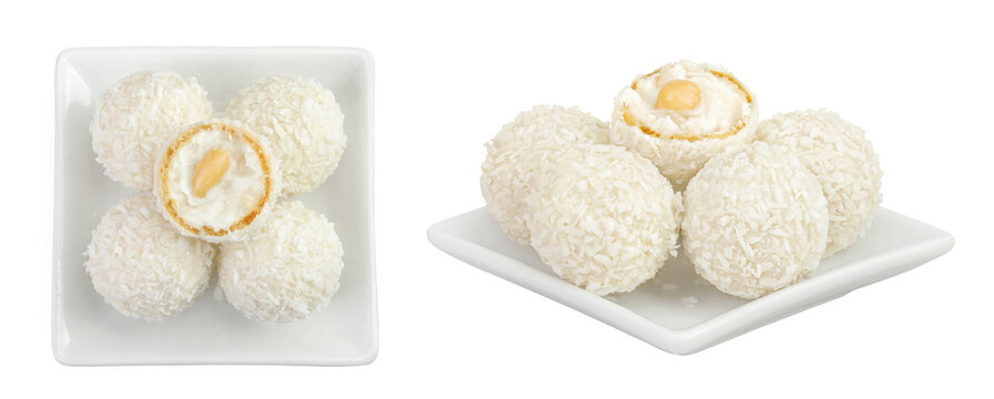 round candy raffaello with coconut flakes and nut in ceramic bowl isolated on white background. Top view. Flat lay.