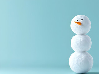 Obraz premium A minimalist snowman made of three snowballs with a single carrot nose, set against a pale blue background. A simple snowman illustration.