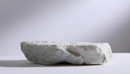 Rough stone podium for presentation, white tones. Abstract empty pedestal for product presentation.